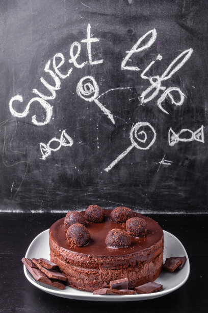 一块白瓷盘上的巧克力蛋糕，石板的背景上刻着“甜蜜的生活”图片下载