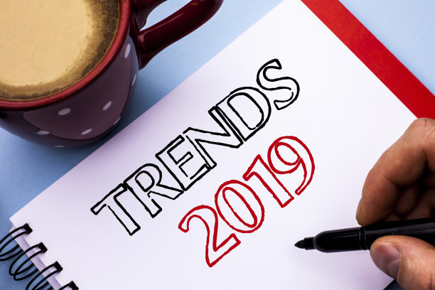 写便条显示2019年趋势。商业照片展示当前运动最新品牌新概念预测写在笔记本上，握笔在朴素的背景咖啡杯。图片下载