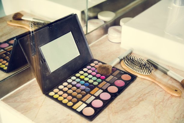 化妆用具和梳子放在桌上图片下载