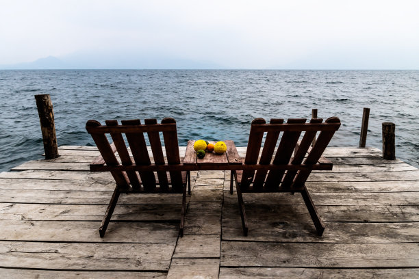 危地马拉阿提特兰湖的圣克鲁兹拉古纳码头上，两把放着水果的放松椅图片下载