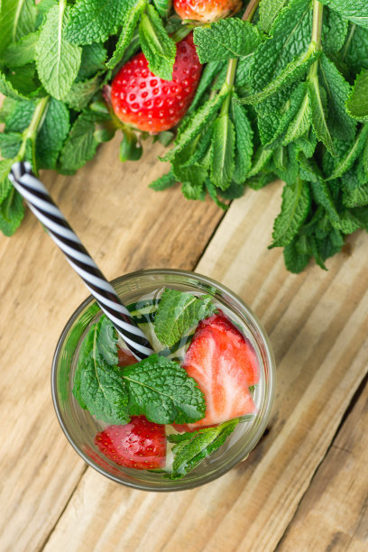 玻璃与新鲜的冷却注入排毒水与成熟的有机草莓黄瓜片薄荷。板木的背景。健康饮料排毒夏日茶点。本空间图片下载