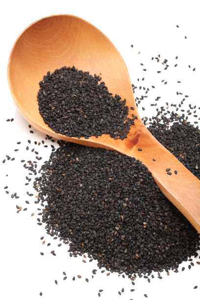 黑芝麻在木勺中孤立在白色背景上素材图片