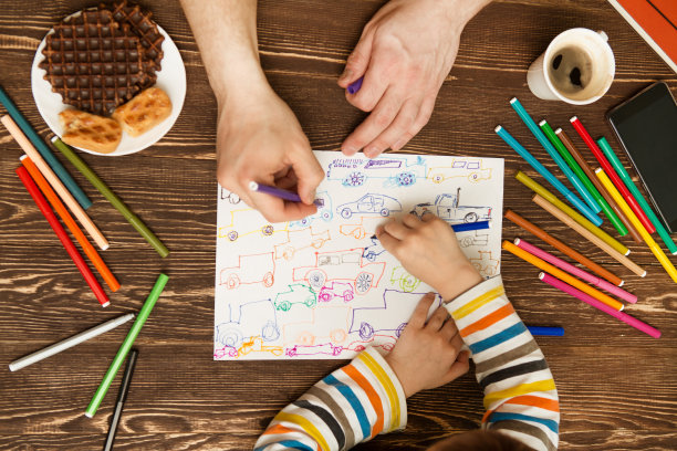 幸福的家庭。孩子和父亲的手用毡尖笔画。俯视图创意照片的手小男孩和父亲在古董棕色木制桌子。图片下载