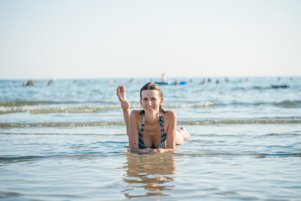 一个微笑的女人躺在海里的肖像图片下载