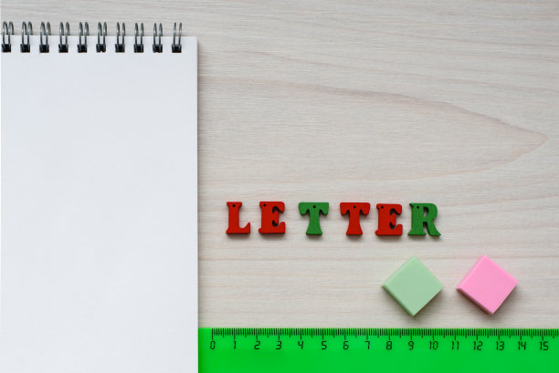 开发儿童创意配件，画册，尺子，橡皮和铭文从多色的木制字母字母在一个木制的背景图片下载