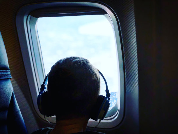 小男孩望着飞机窗外图片下载