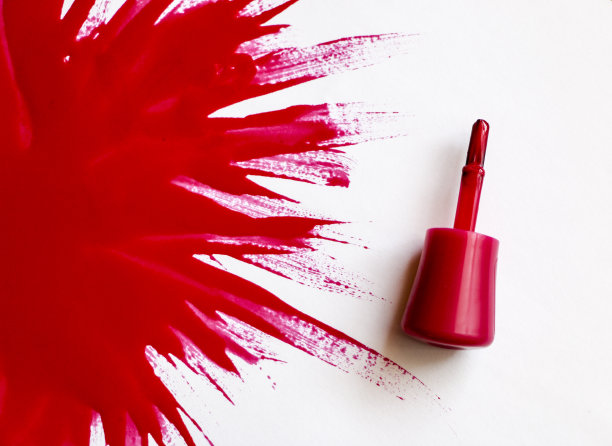 红色的指甲油。爆炸的颜色。用红色指甲油在白色背景上涂上一大块清漆。图片下载