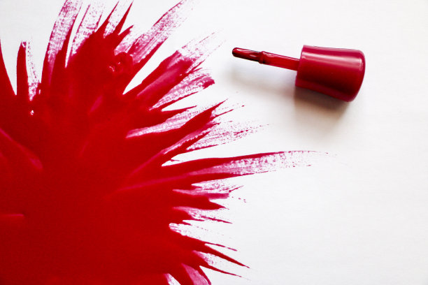 红色的指甲油。爆炸的颜色。用红色指甲油在白色背景上涂上一大块清漆。图片下载