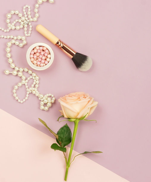 鲜玫瑰花，化妆品和珍珠项链在淡粉色紫色的背景。前视图。本空间图片下载