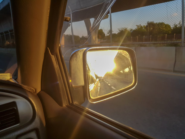 高速公路下美丽的后视镜和夕阳下的阳光照耀着大桥。旅行或交通运输的概念图片下载