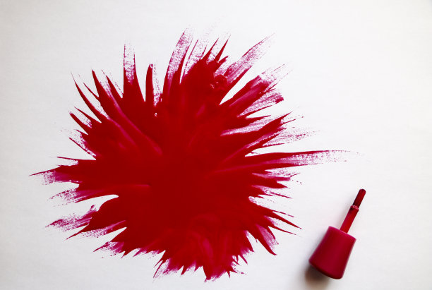 红色的指甲油。爆炸的颜色。用红色指甲油在白色背景上涂上一大块清漆。图片下载