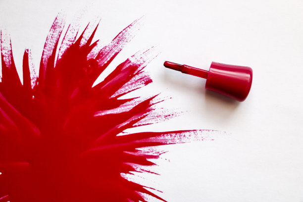 红色的指甲油。爆炸的颜色。用红色指甲油在白色背景上涂上一大块清漆。图片下载