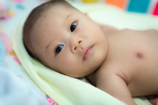 小婴儿洗澡后在床上用毛巾洗澡。图片下载