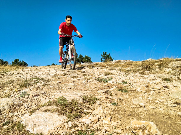 人骑自行车。极端自由滑雪下坡图片下载