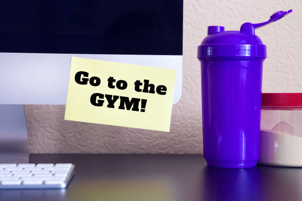 现代电脑与提醒黄色贴纸笔记与文字:去健身房!(桌上有奶昔和健身补品)图片下载