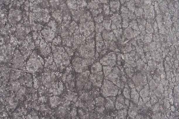 尘土飞扬的旧混凝土路面开裂图片下载