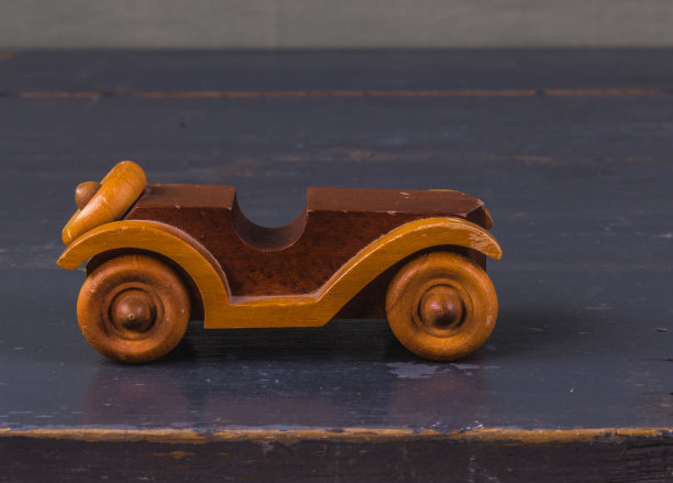 天然木制的旧汽车玩具在木制的灰色背景上，复古图片下载