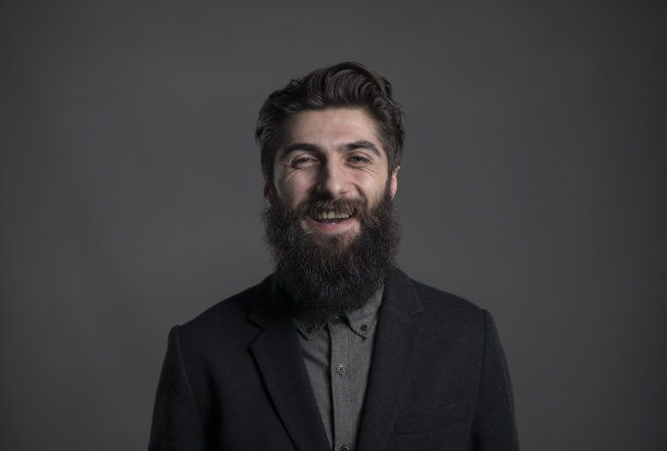 一个潮人的肖像站在一个背后的背景与他的微笑在他的脸上。图片下载