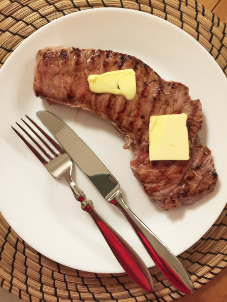 牛扒和黄油放在盘子里图片下载