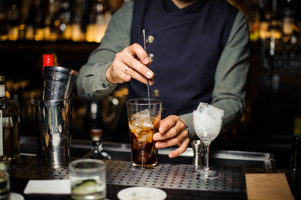 调酒师用玻璃杯调制酒精鸡尾酒素材图片