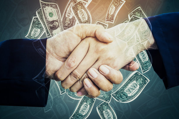 两个商人或合作伙伴握手与钞票的背景图片下载