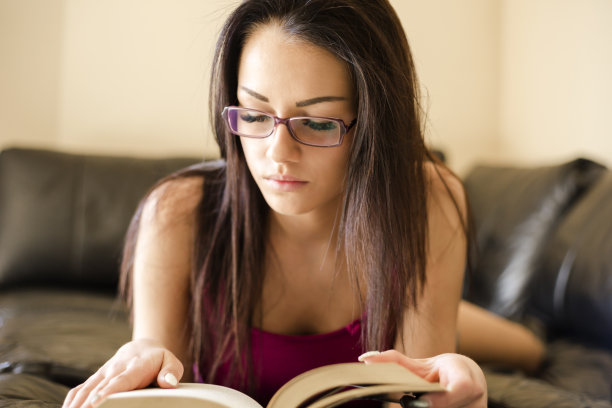 年轻女子在家里读书图片下载