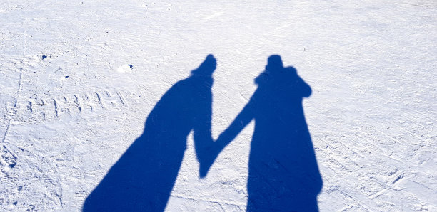 白色雪花上的夫妻的影子图片下载