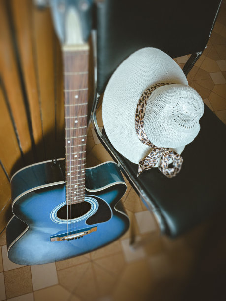 原声吉他与女士的帽子。图片下载