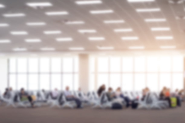 模糊的背景，乘客在机场候机楼等待航班。图片下载