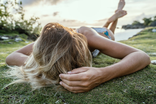 年轻女人在热带岛屿日落时放松图片下载