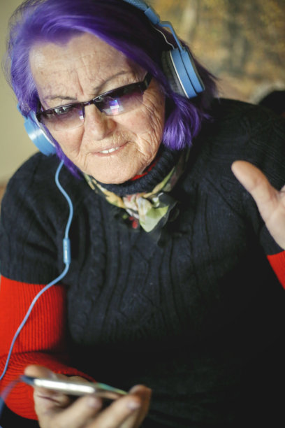 老女人通过大耳机听她最喜欢的音乐图片下载