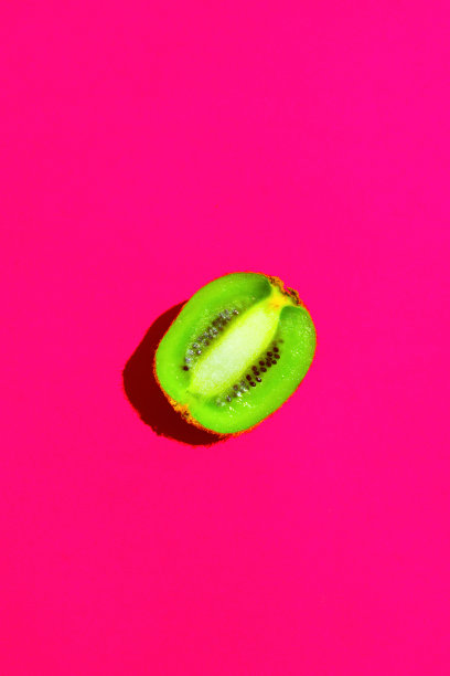 半熟多汁猕猴桃，桃红背景。明亮刺眼的阳光深深的阴影。充满活力的霓虹灯的颜色。夏季热带度假旅游时尚概念。海报横幅横幅模板图片下载