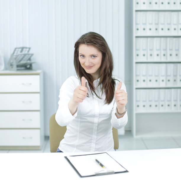 在工作场所竖起大拇指的女商人图片下载