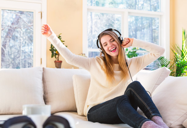 快乐的年轻女子戴着耳机听音乐素材图片