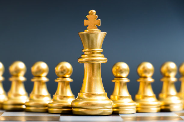 黑色背景上的金色国王棋子（领导力管理概念）素材图片