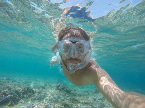 一名年轻人戴着潜水面罩在水下自拍图片下载