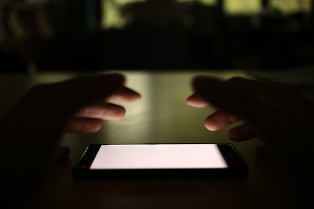 白屏手机。社交网络智能手机成瘾概念。男人伸手拿智能手机。图片下载