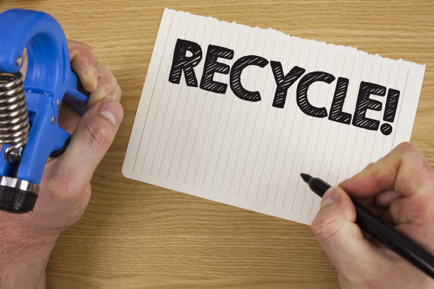 文字标志显示循环动机呼唤。将废物转化为可再用材料的概念照片，作者:Man on Tear Notebook, paper Marker and Tool，在木制背景上。图片下载