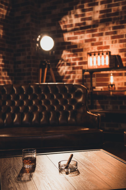 阁楼内。皮沙发，桌上放着一杯威士忌和雪茄图片下载