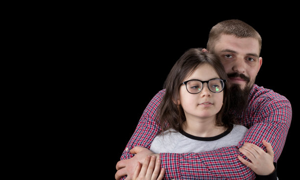 帅气的父亲和他可爱的女儿拥抱的肖像，看着相机和微笑图片下载