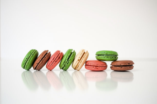 彩色的马卡龙或白色木质背景上的马卡龙。法国美味的糕点。图片下载