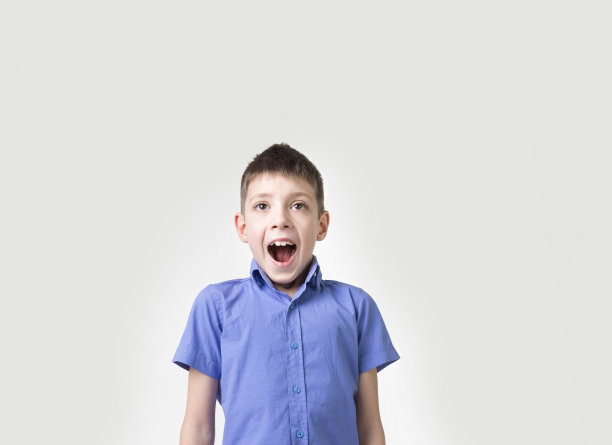 情绪肖像的愤怒大喊十几岁的男孩。愤怒的青少年看着镜头尖叫图片下载