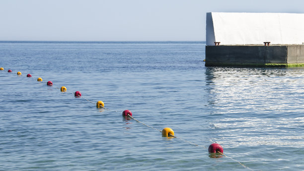 码头附近的海上有黄色和红色的浮标图片下载