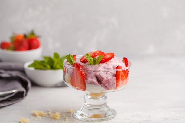 草莓甜点。英国浆果松糕，芝士蛋糕，冻糕。莓果慕斯在玻璃上在一个轻的背景。素材图片