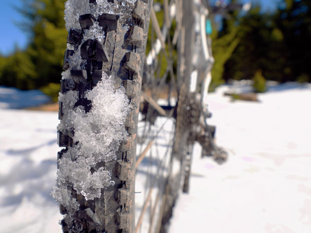 雪地山地自行车，在新鲜的雪地上骑着大轮胎自行车图片下载