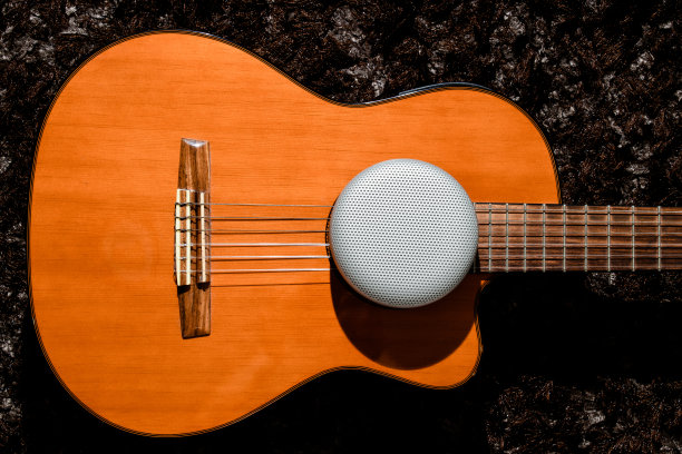高保真扬声器上的紫色古典吉他与黑暗的背景图片下载
