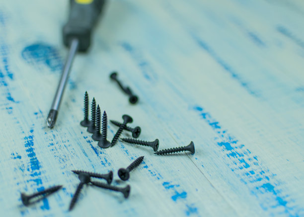 木背景上的螺丝和螺丝刀。修理的概念。图片下载