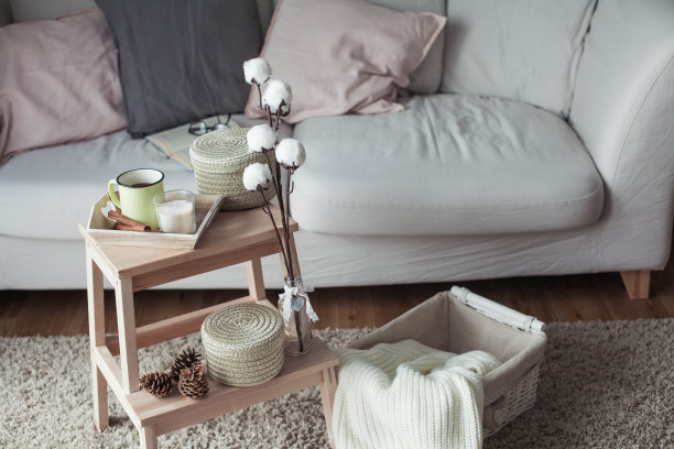 家居装饰。一张木制床头柜，一张沙发，一块棉布，一杯热咖啡，一件针织格子呢。温暖的房子。秋天。舒适。的房子。书和眼镜。内部。图片下载