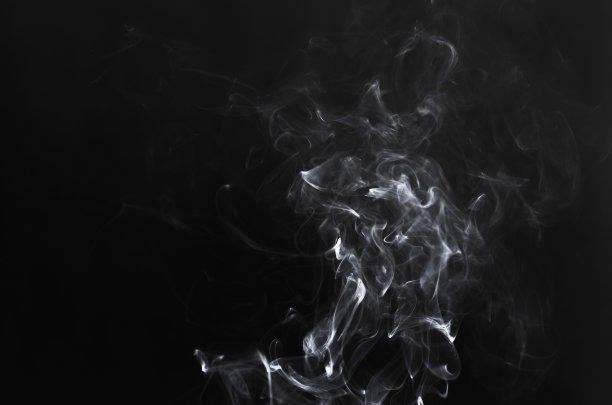 白色烟雾在黑色背景上的抽象碎片运动。素材图片