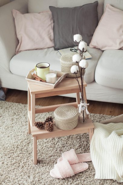 家居装饰。一张木制床头柜，一张沙发，一块棉布，一杯热咖啡，一件针织格子呢。温暖的房子。秋天。舒适。的房子。书和眼镜。内部。图片下载